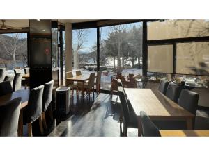 大石市にあるAshiwada Hotel - Vacation STAY 75392vの雪が降り注ぐテーブルと椅子が備わるレストラン