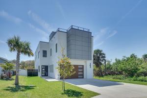a white house with a tree in front of it at Walk to Shore Modern Stunner in Ormond Beach! in Ormond Beach