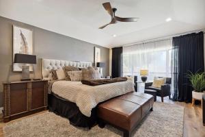 Un dormitorio con una cama grande y un ventilador de techo. en Zen Back Yard with Hot Tub, Firepit, Spa at Home, en Dallas
