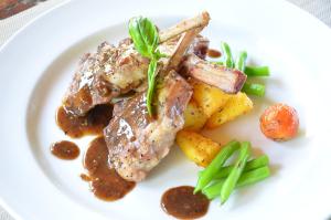 a plate of food with meat potatoes and gravy at Pool Villa Merumatta Senggigi in Senggigi