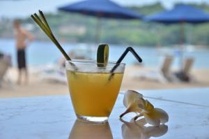 a drink sitting on a table near a beach at Pool Villa Merumatta Senggigi in Senggigi