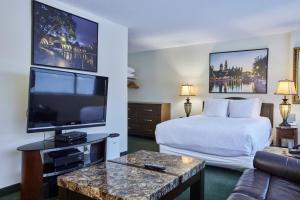 a hotel room with a bed and a flat screen tv at The Business Inn in Ottawa