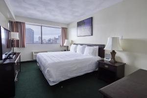 a hotel room with a bed and a large window at The Business Inn in Ottawa