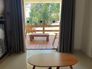 a living room with a table and a patio at Maluhia Ilhabela 1 in Ilhabela