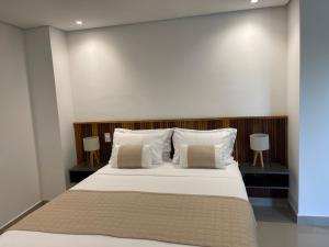 a bedroom with a large bed with white sheets and pillows at Maluhia Ilhabela 1 in Ilhabela