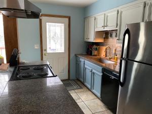 a kitchen with a stainless steel refrigerator and blue cabinets at Two Bedroom in Great Location in Fairbanks