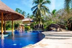 a swimming pool at a resort with a waterfall at Pool Villa Merumatta Senggigi in Senggigi