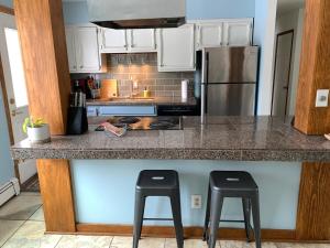 a kitchen with a counter with two stools at it at Two Bedroom in Great Location in Fairbanks +12 photos