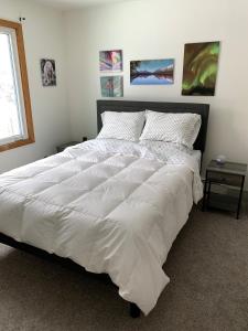 a large white bed in a bedroom with a window at Two Bedroom in Great Location in Fairbanks