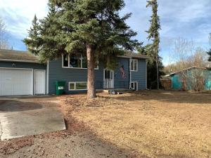 a house with a tree in front of it at Two Bedroom in Great Location in Fairbanks