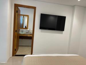 a flat screen tv on the wall of a bedroom at Maluhia Ilhabela 1 in Ilhabela