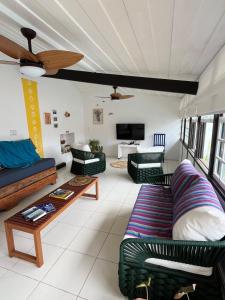 een woonkamer met banken en een tafel bij Casa La Buziana in Búzios