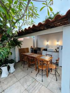 een patio met een tafel en stoelen en een keuken bij Casa La Buziana in Búzios +45 foto's