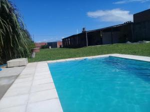 a swimming pool with blue water in a yard at Villa del Sol in Salta