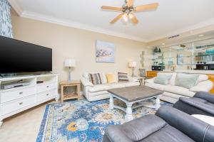 a living room with a couch and a flat screen tv at Phoenix on the Bay 1429 condo in Orange Beach +40 photos