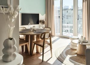ソポトにあるN736 Sopot Suite - 55m2 apartament premium z 2025 rokuのテーブルと椅子とテレビのあるリビングルーム +12枚の写真