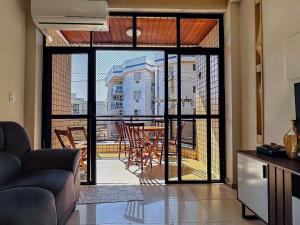 a living room with a large glass door leading to a patio at Apartamento para família na praia do forte in Škorak
