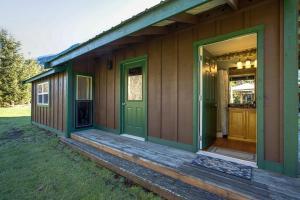 a house with a green door and a porch at Making lasting memories while enjoying this unique glamping experience in Maple Falls