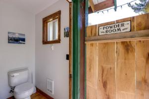 a bathroom with a toilet and a wooden door at Making lasting memories while enjoying this unique glamping experience in Maple Falls
