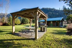 a picnic shelter with a picnic table and a cabin at Making lasting memories while enjoying this unique glamping experience in Maple Falls