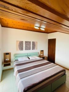 a large bed in a room with a wooden ceiling at Blue Pearl Beach House in Sozopoli