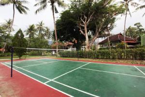 a tennis court in front of a house with palm trees at Pool Villa Merumatta Senggigi in Senggigi