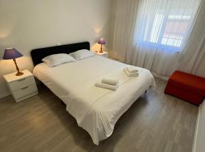 Un dormitorio con una cama blanca con toallas. en Santiago Apartment, en Caminha