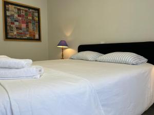 Una cama blanca con dos almohadas encima. en Santiago Apartment, en Caminha 5 fotos más