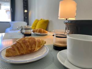 a plate with a pastry on a table with a cup of coffee at Santiago Apartment in Caminha