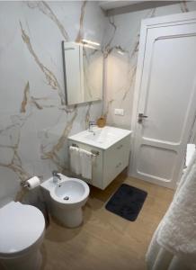 a bathroom with a white toilet and a sink at Il Cortile in Caccamo +28 photos