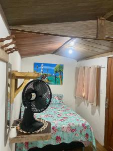 a bedroom with a bed with a fan on a table at Balneário Rio Agua Viva - Chalé com Ventilador in Areia