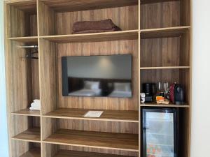 a entertainment center with a television in a room at Maluhia Ilhabela 4 in Ilhabela