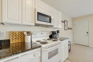 a kitchen with a white stove and a microwave at Rainbow Cove --- 117 Dagsworthy Ave #B in Dewey Beach
