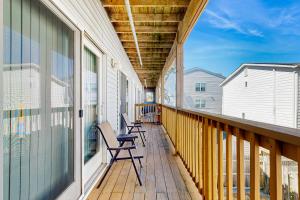 a balcony with chairs and awning on a house at Rainbow Cove --- 117 Dagsworthy Ave #B in Dewey Beach