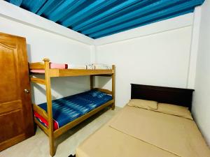 a bedroom with a bunk bed and a blue ceiling at La Posada Nápoles in Doradal