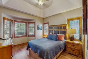 a bedroom with a bed and a desk and windows at Reserve 05-A in Sugar Mountain
