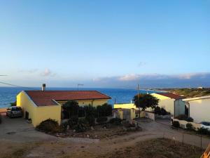 a row of houses with the ocean in the background at Appartamento Sunset in La Ciaccia