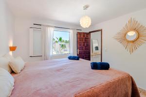 a bedroom with a large bed with blue pillows on it at Sunset SPA Villa Cala Tarida in Sant Josep de sa Talaia