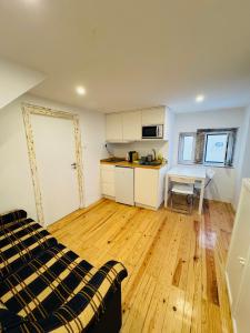 a room with a bed and a kitchen with a table at Travessa do Meio Apartment in Lisbon