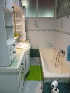 a bathroom with a tub and a sink and a bath tub at La résidence du sportif Bernard in Anse-Bertrand