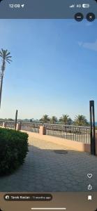 a rendering of a beach with a fence and palm trees at Mina house in Ain Sokhna