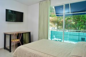 a bedroom with a bed and a view of a pool at HOTEL AQUARELLA DEL MAR in Santa Marta