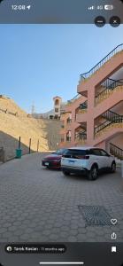 two cars parked in a parking lot in front of a building at Mina house in Ain Sokhna