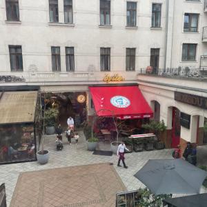 a building with a red awning in a courtyard at Klikk Apartments at Gozsdu in Budapest