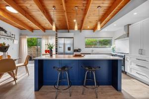 a kitchen with a blue island in the middle at Hillview Delights - Waihi Beach Holiday Home in Waihi Beach