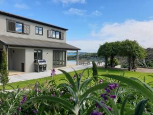 a house with a garden in front of it at Cable Bay Luxury Villa in Oneroa