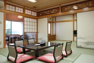 una sala da pranzo con tavolo e sedie di Okumizuma Onsen a Kaizuka