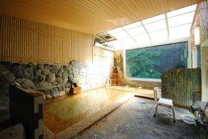 a room with a large window and an aquarium at Okumizuma Onsen in Kaizuka