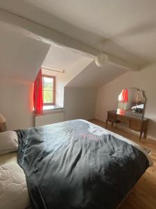 una camera da letto con un letto grande in una mansarda di Le Refuge de Libin a Libin