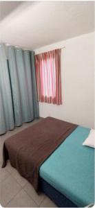 a bedroom with a bed and two windows with curtains at Bleu miami in Argelès-sur-Mer